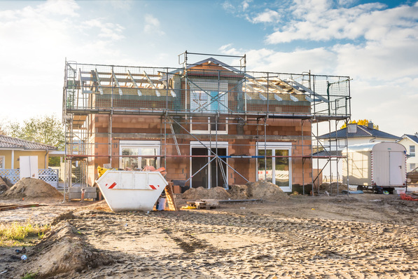Alt-Text: „Teilweise fertiggestelltes Smart Building mit sichtbarer intelligenter Gebäudetechnik, umgeben von Baustelleninfrastruktur, im Kontext einer modernen Bauplanung mit BIM und digitaler Gebäudesteuerung. - © DanBu.Berlin - stock.adobe.com