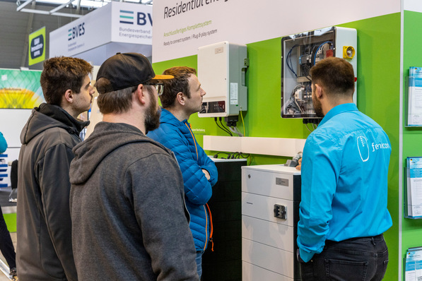 Gerne. Hier ist ein optimierter Alt-Text für das beschriebene Bild: „Vier Fachleute begutachten die Demonstration eines innovativen Energiespeichersystems am Ausstellungsstand, das Lösungen für effizientes Energiemanagement und Integration in intelligente Gebäudeumgebungen bietet.“. - © Landesmesse Stuttgart