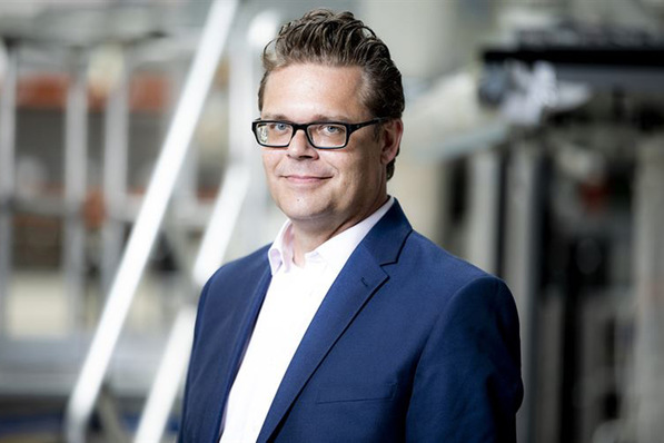 Gerne! Hier ein optimierter und themenrelevanter Alt-Text für das beschriebene Bild, passend zur Zielgruppe und dem Content-Kontext von tga-fachplaner.de: Alt-Text: „Fachplaner für Gebäudetechnik im Anzug blickt freundlich in die Kamera; im Hintergrund modernes Büro, Symbol für Digitalisierung und intelligente Systemintegration in der TGA-Branche.“ Soll es fachlich noch spezifisch (je nach Artikelthema) angepasst werden? Beispiel: „TGA-Fachplaner bei der Projektbesprechung zu digitalem Energiemanagement in Gebäuden – Sinnbild für die zunehmende Digitalisierung und Vernetzung technischer Gebäudeausrüstung.“. - © Daikin